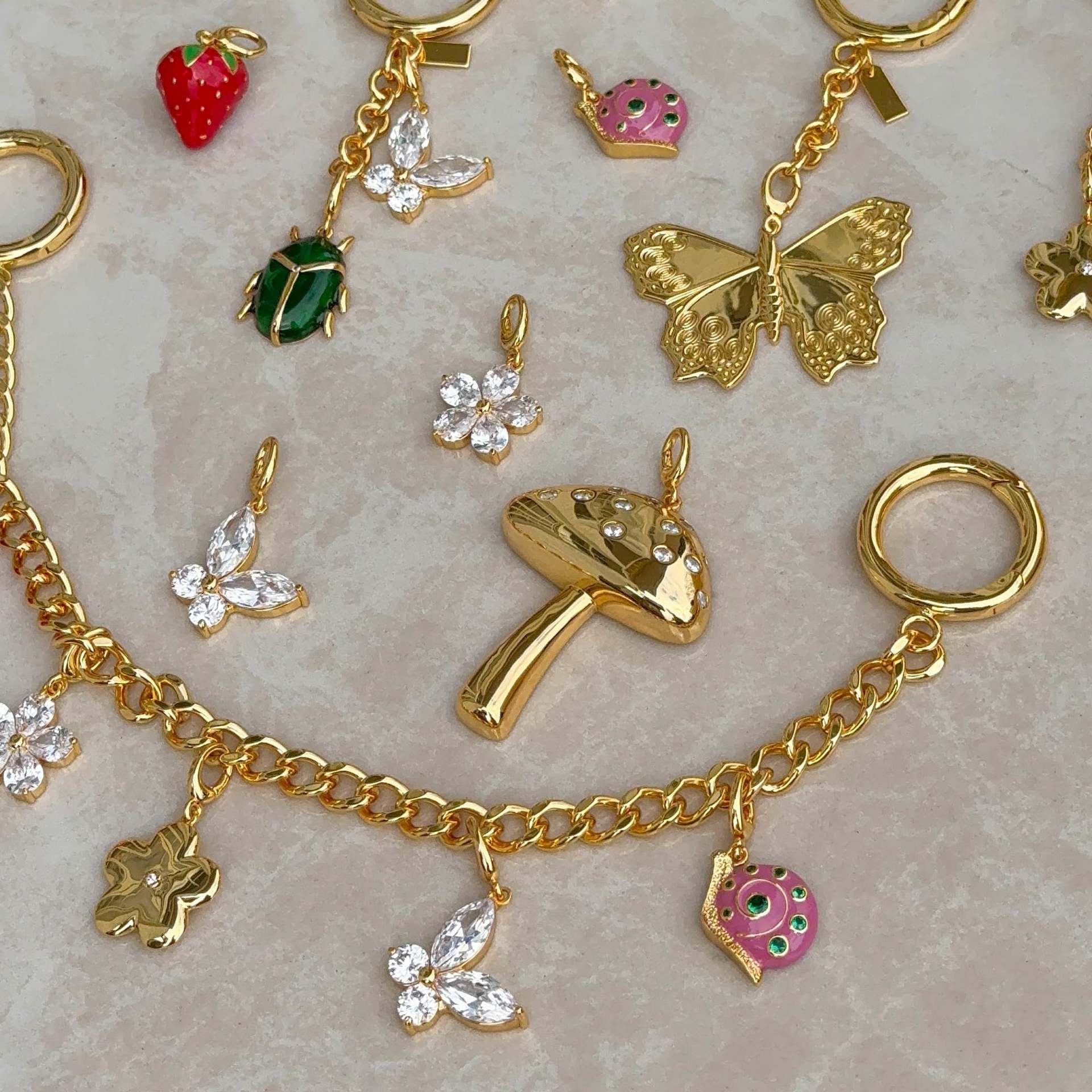 Stainless steel bag charm bracelet with strawberry, flower, and dinosaur pendants